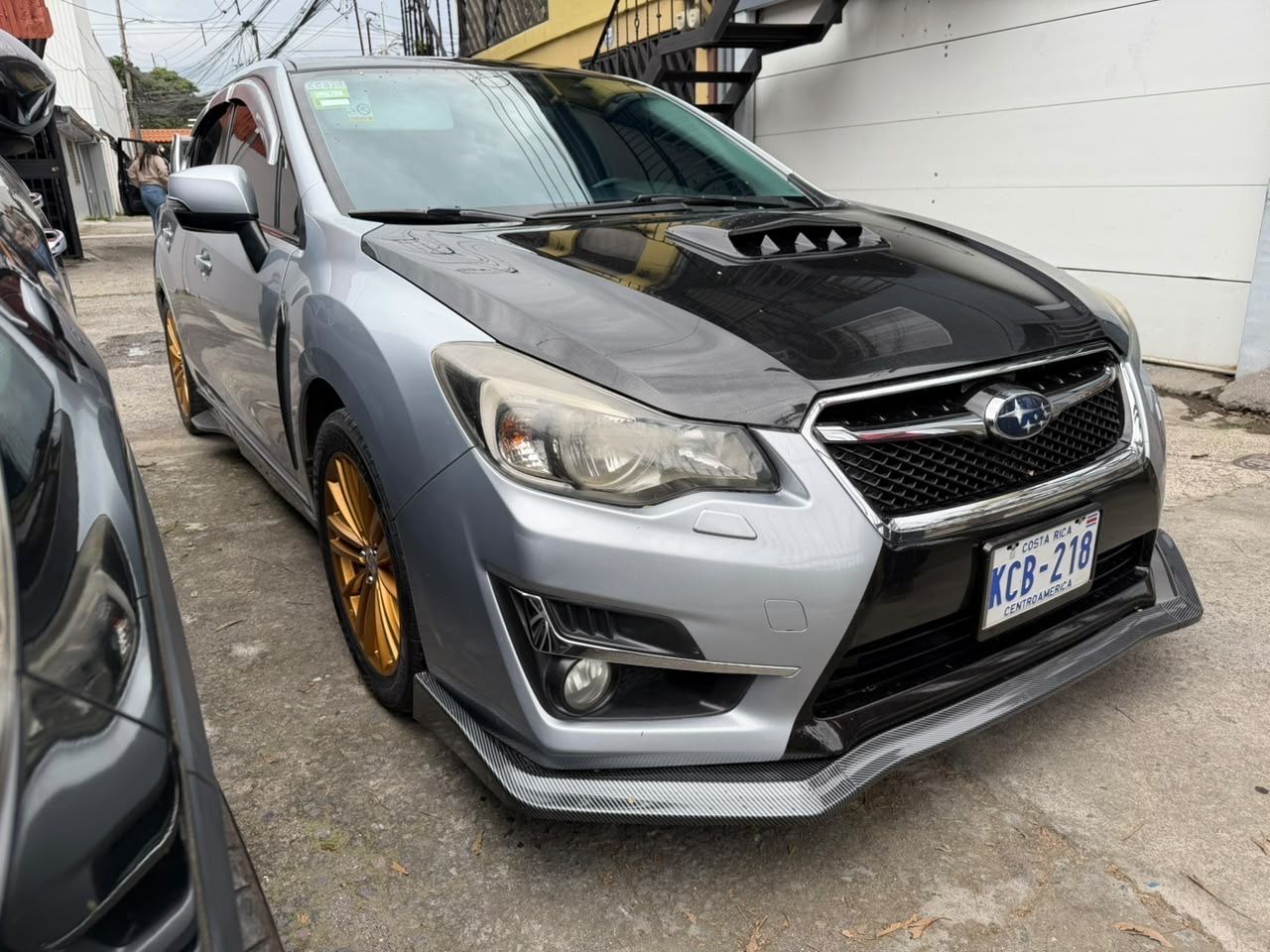 Frente del Subaru Impreza Sport 2016 mostrando la parrilla, el labio de carbono y la toma de aire del capó